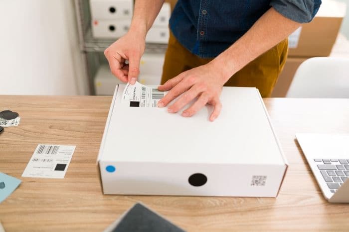 male-putting-shipping-label-to-a-package
